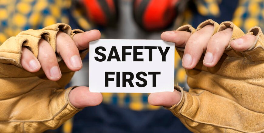 front-view-hands-holding-safety-first-sign